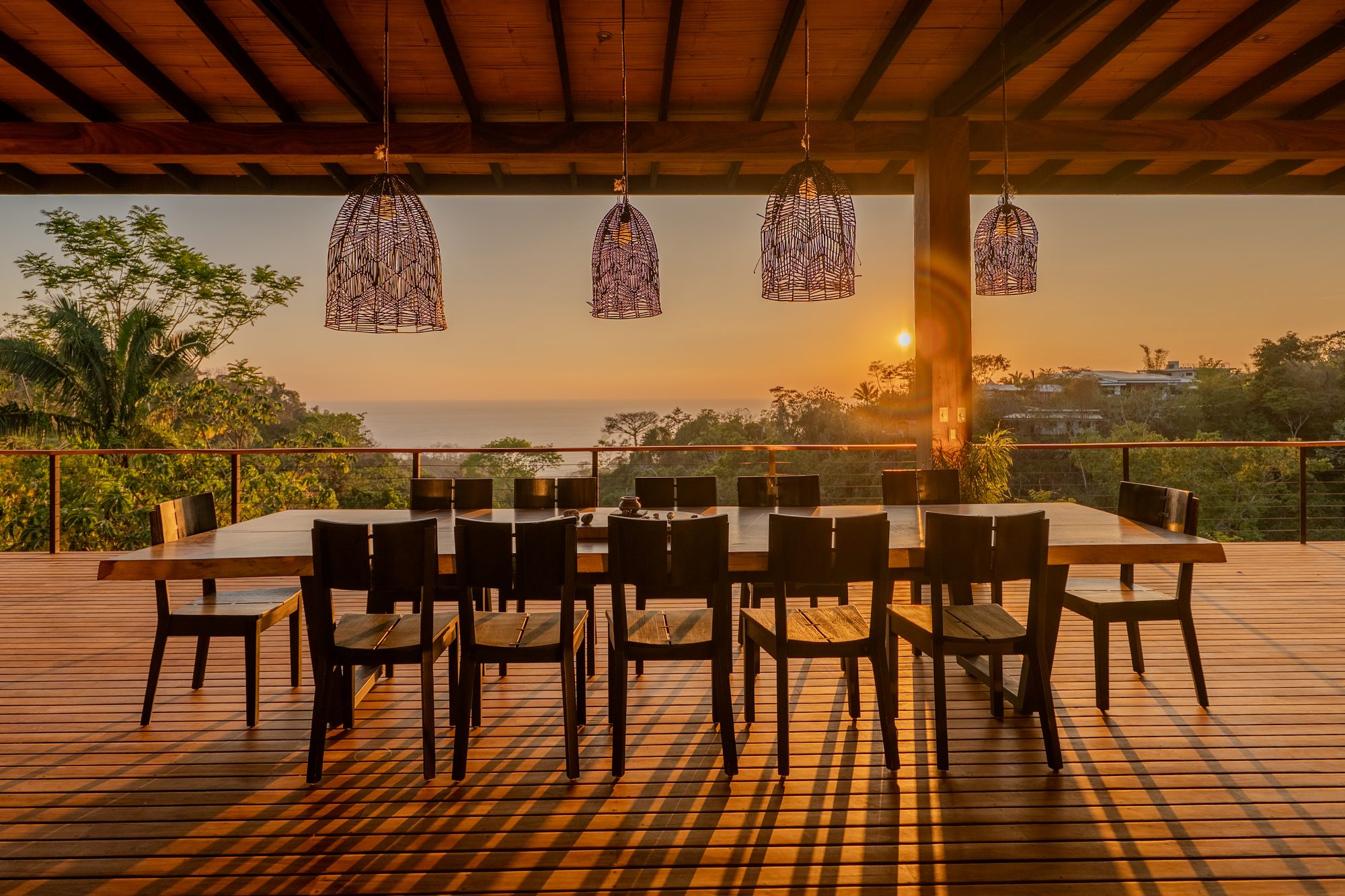 Long table set for a group dinner at sunset on the terrace
